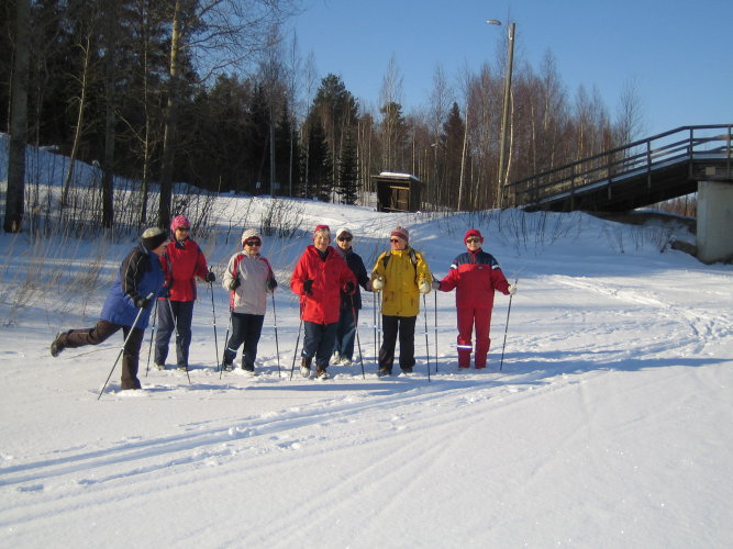 Naiset sauvakävelyllä lumihangessa