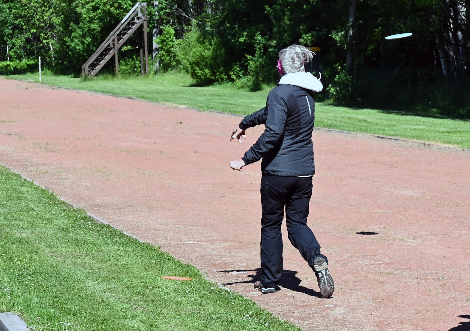 Nainen heittää Frisbee-keikkoa korille
