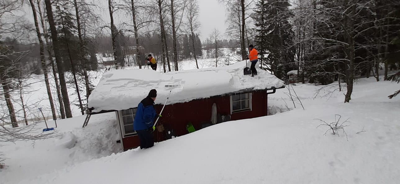 Äijät lumenpoistossa katolta