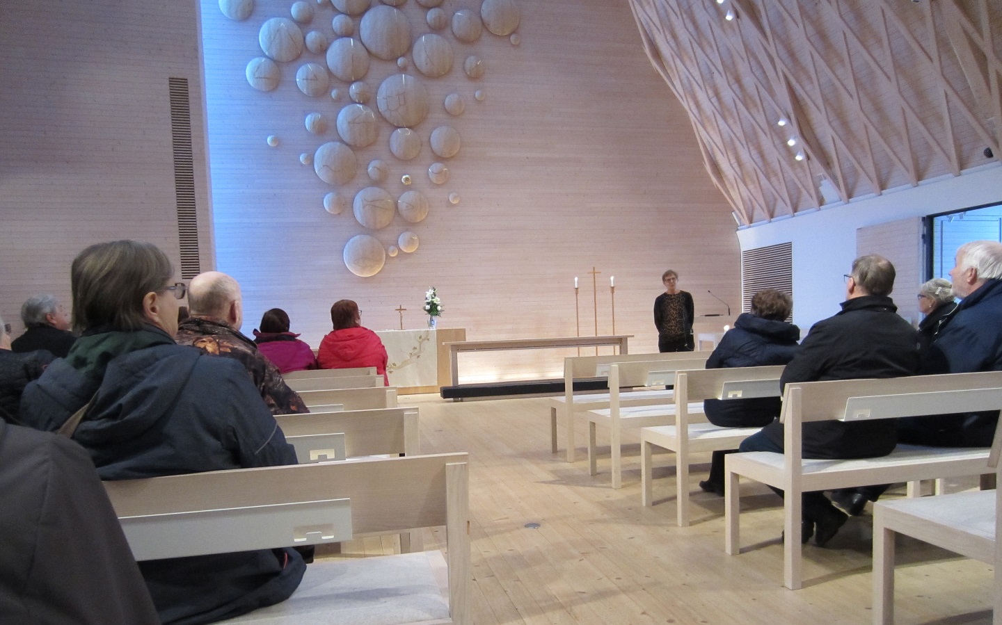 Kuokkalan kirkossa Jyväskylässä vieraat ihastelevat kaunista alttaritaulua