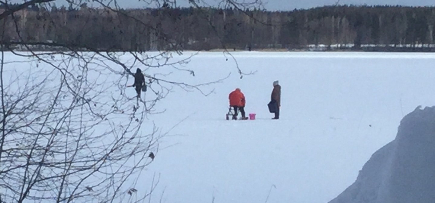 Luminen maisema, jossa kolme henkilöä ovat pilkkimässä