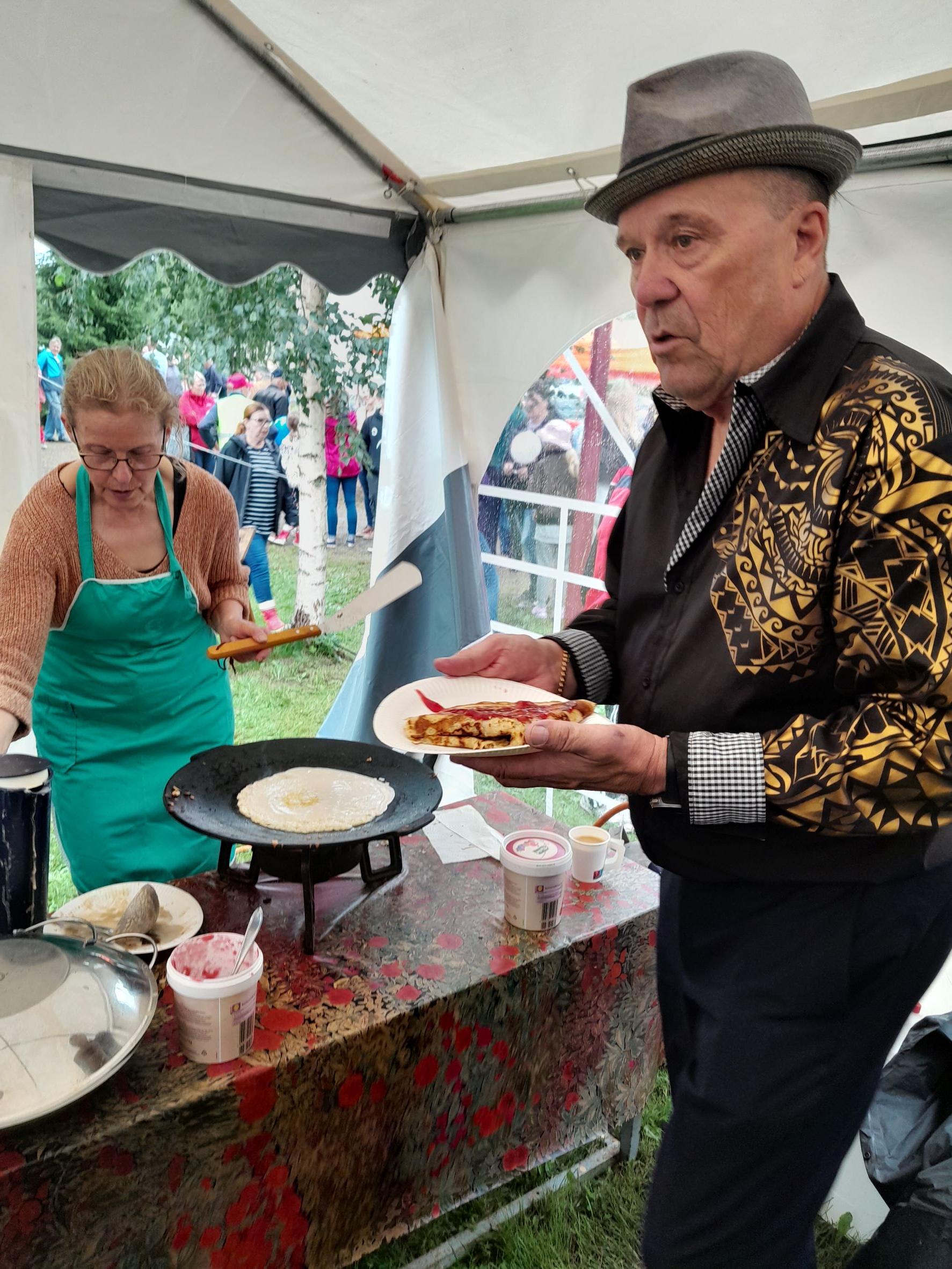 Jaska Mäkynen yhdistyksen teltalla lettukahvilla, tarjoilussa Hannele Kivijärvi.