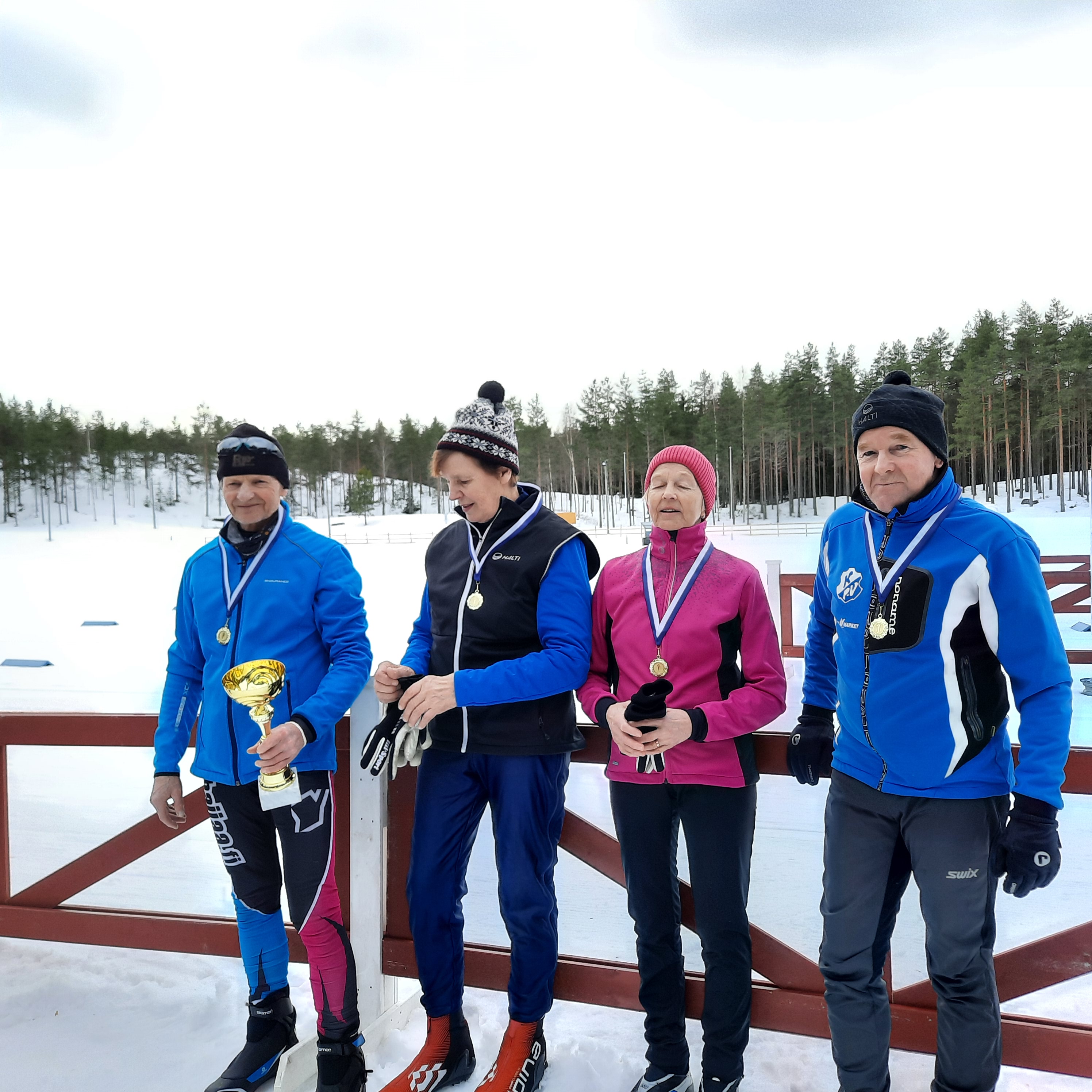 Hiihtäjiä kultamitalit kaulassa
