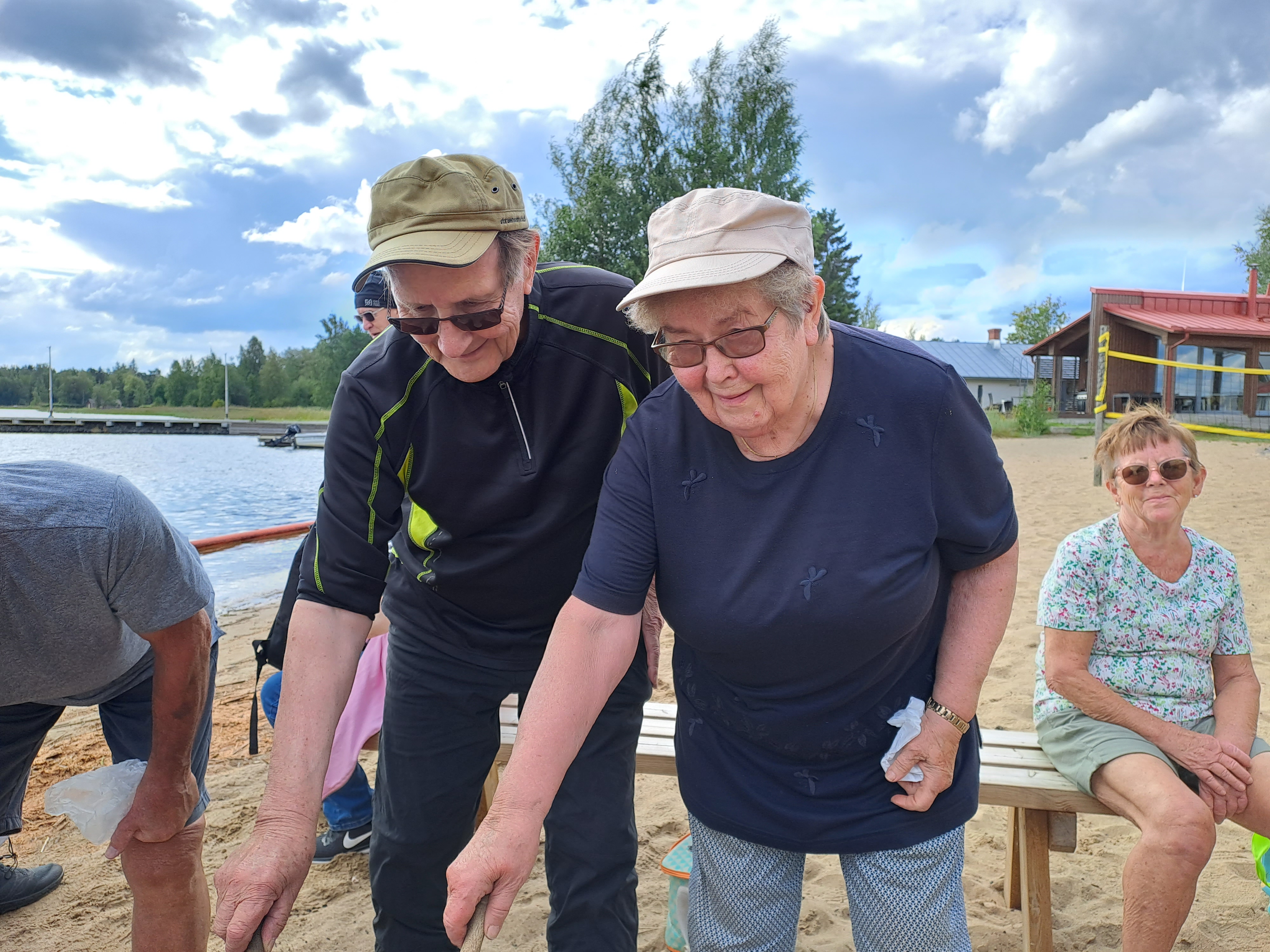 Ystävykset Leo ja Marjatta makkaran grillauksessa.