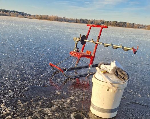 Pilkkijän punainen kelkka ja kaira syysjäällä