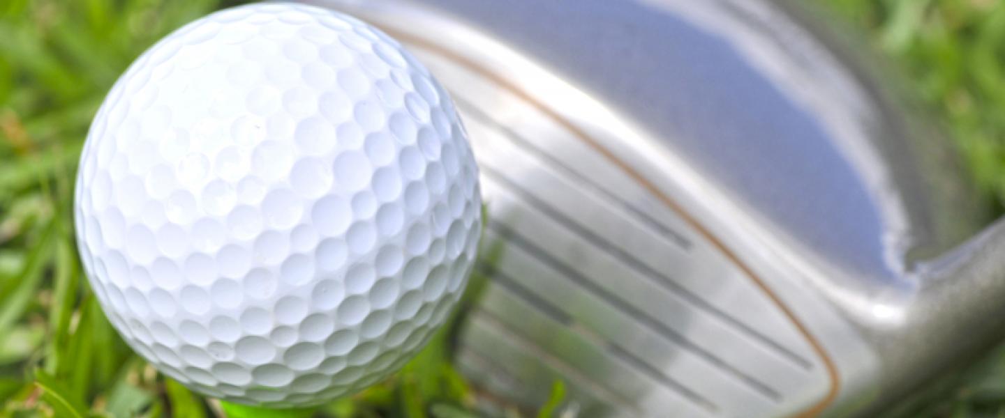 VIhreällä ruohokentällä valkoinen golfpallo