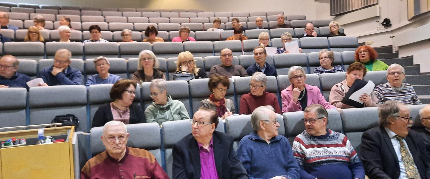 Ihmisiä auditoriossa