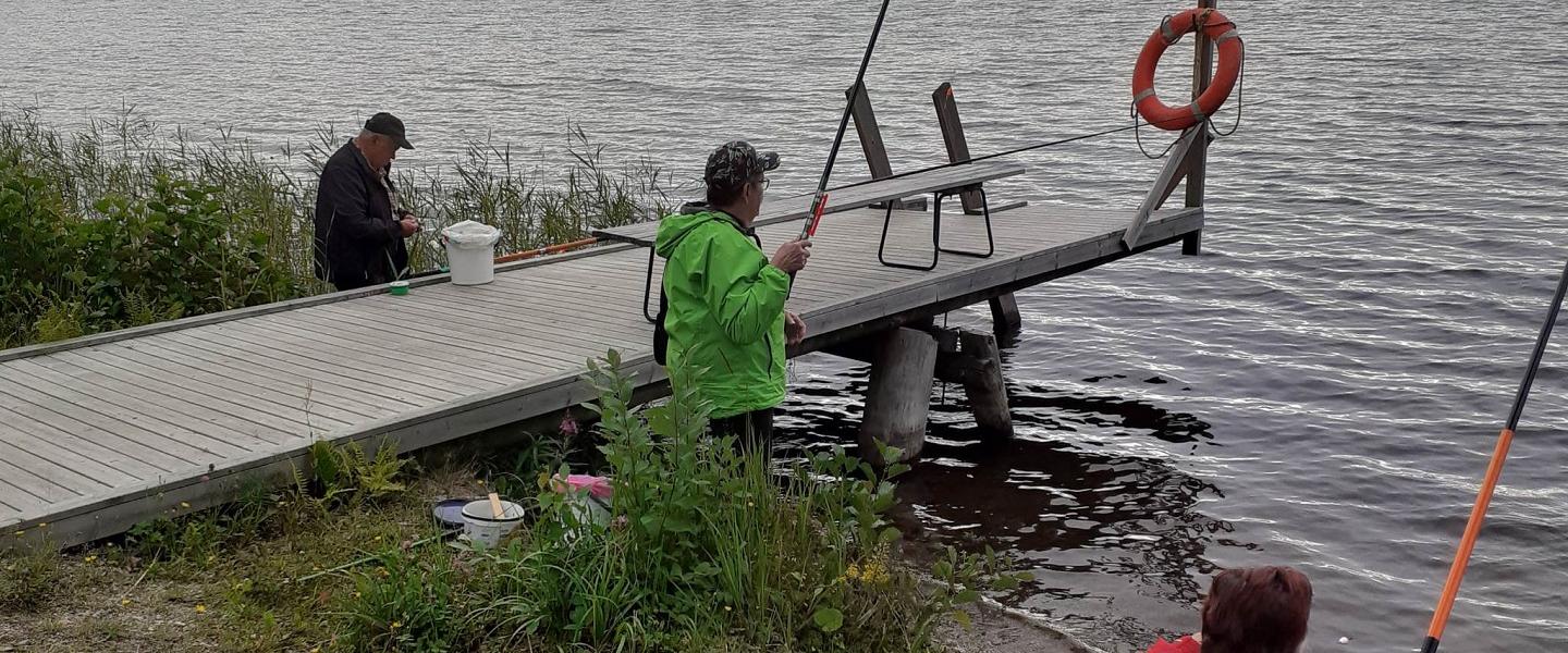 Ihmisiä onkimassa rannalla