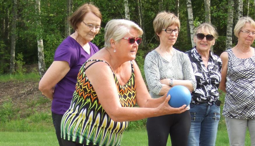 Naiset heittävät keilapalloa ulkona