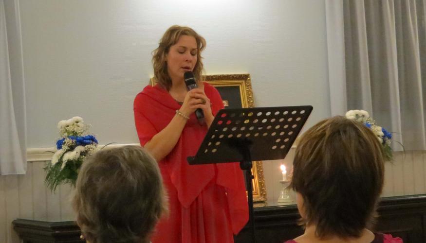 Punapukuinen laulajatar Aleksandra Nisula esiintyy