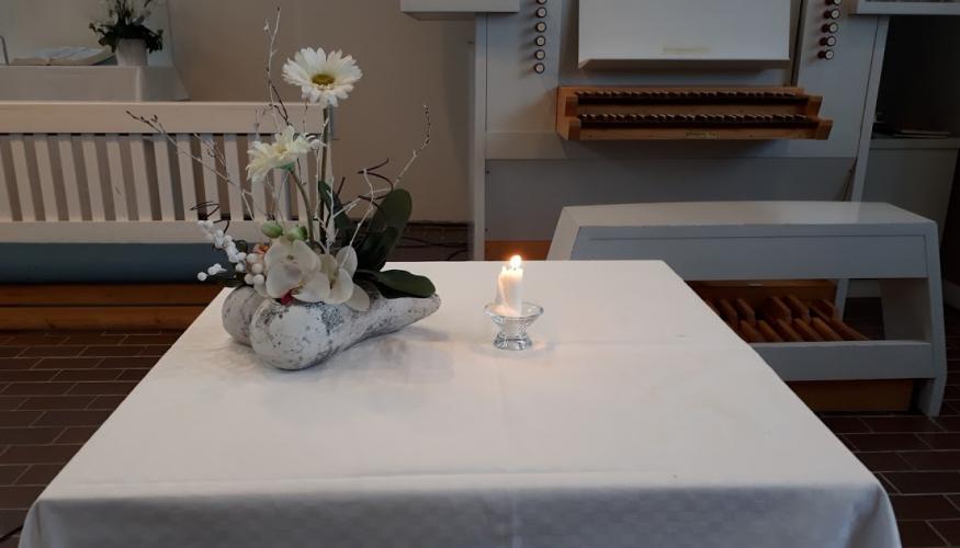 Kukka-asetelmaja kynttilä pöydällä